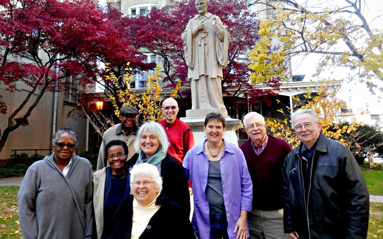 Members of the St. Vincent de Paul Catholic Community in the Germantown section of Philadelphia pose in front of a statue of the parish’s patron saint. (Mercedes Gallese)